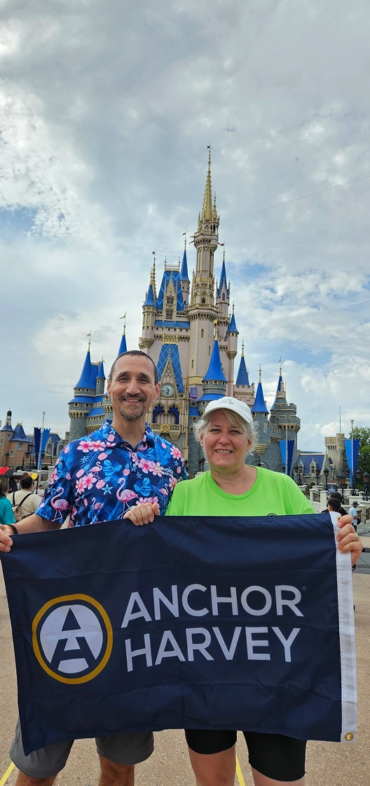 two people holding banner of Anchor Harvey in front of buildings and tower